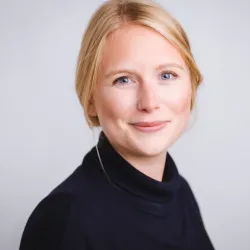 Photograph of a white woman with blonde hair smiling