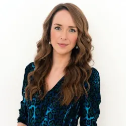 Photograph of a white woman with long brown hair smiling