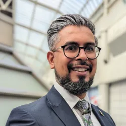 Photograph of a man in a suit smiling