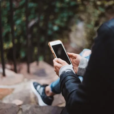 Women on phone outside house