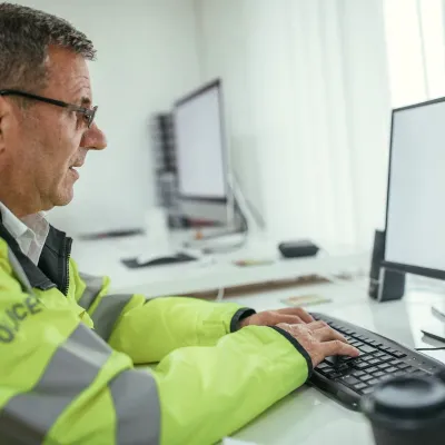 Police man types on a computer