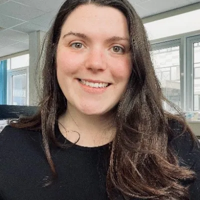 Photograph of a white woman with brown hair smiling
