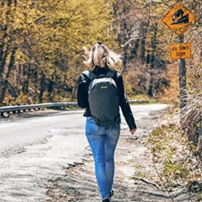 Teenager walking with a diversion sign in background