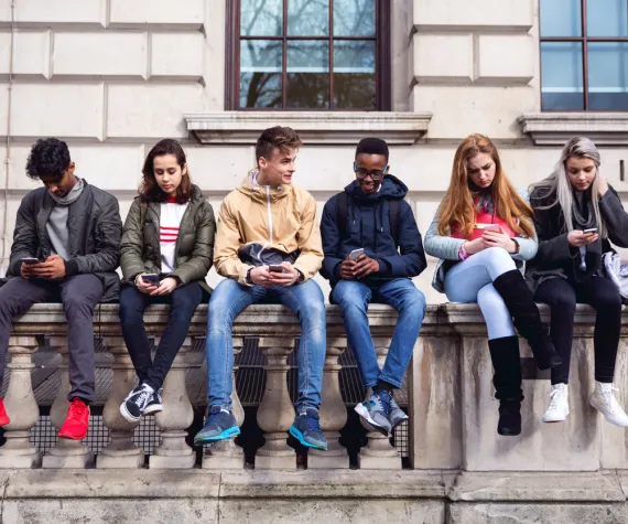 Children of different ethnicity sat on a wall talking