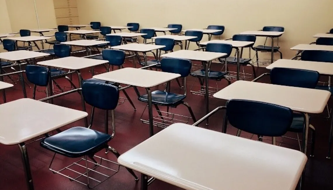 An empty classroom filled with desks. 