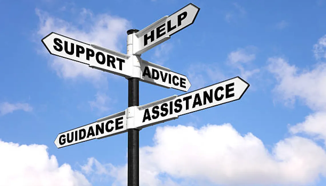 Signs pointing in different directions saying support, help, advice, guidance and assistance