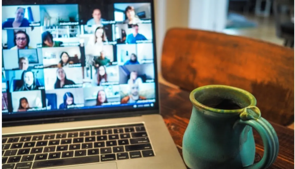Computer showing zoom/video conference with cup of tea