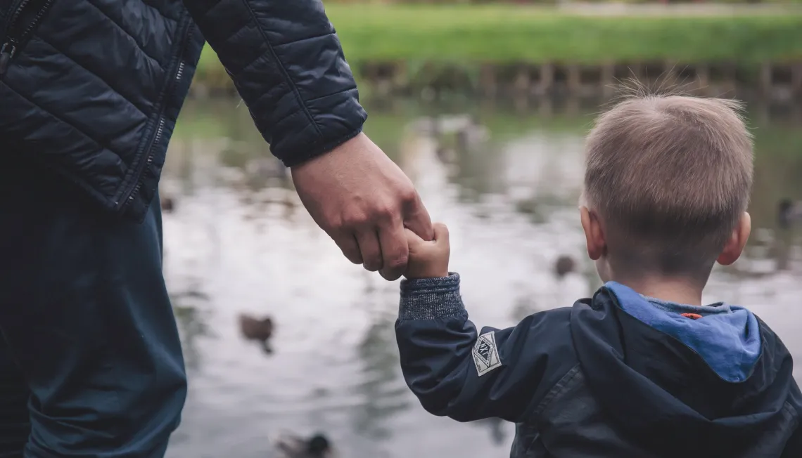 child and parent holding hands